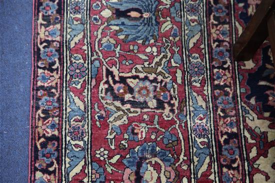 A Persian red and blue ground carpet. 9ft 10in by 7ft 2in.